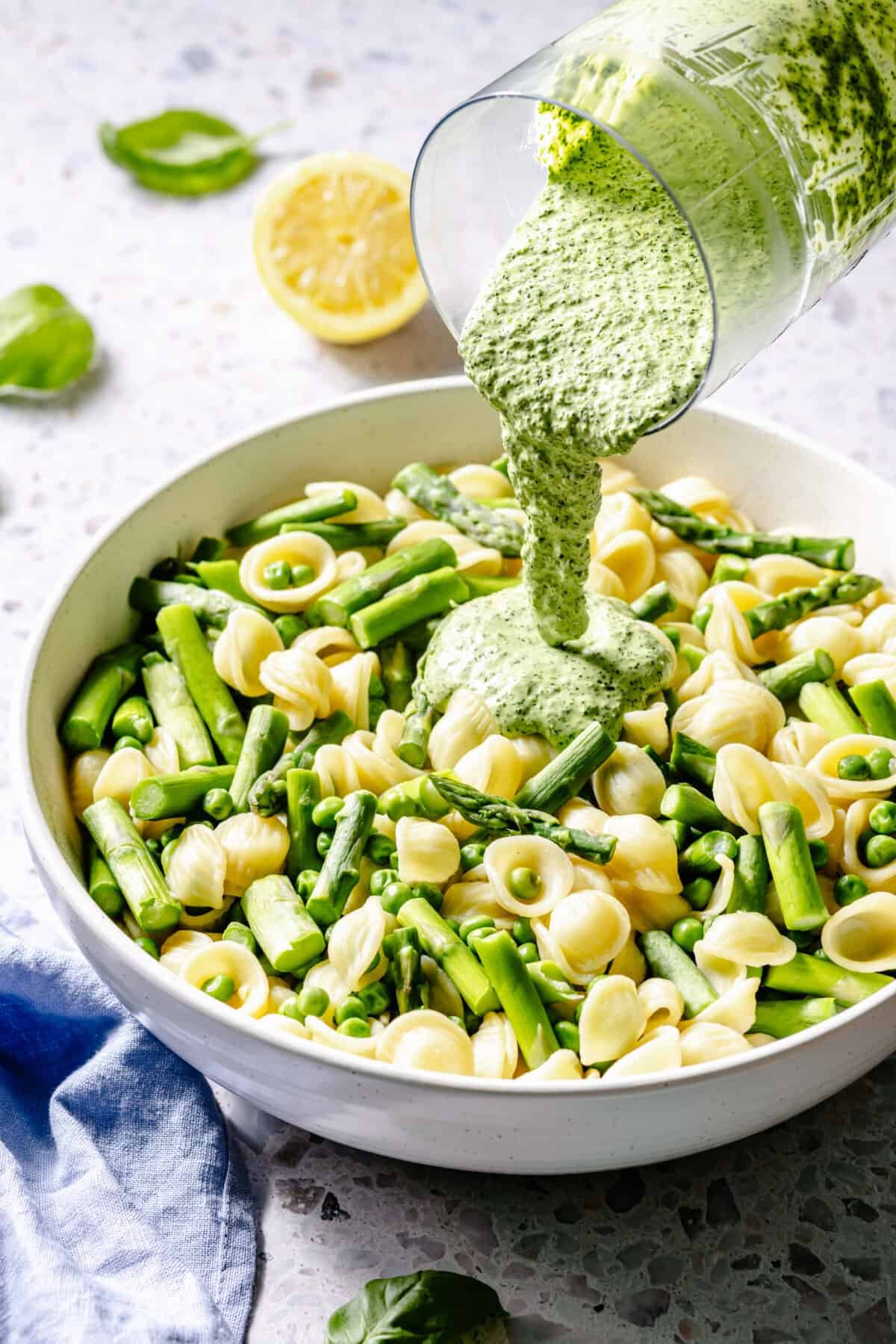 Green Goddess Pasta Salad in bowl with sauce pouring on top.